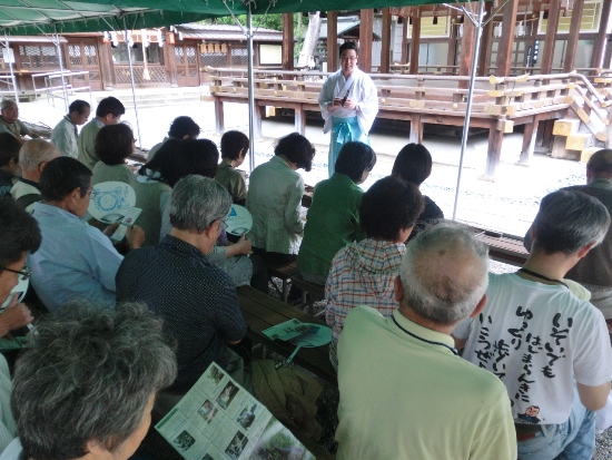 2244-12.6.5護王神社　神官のお話を聞く会員の方々.jpg